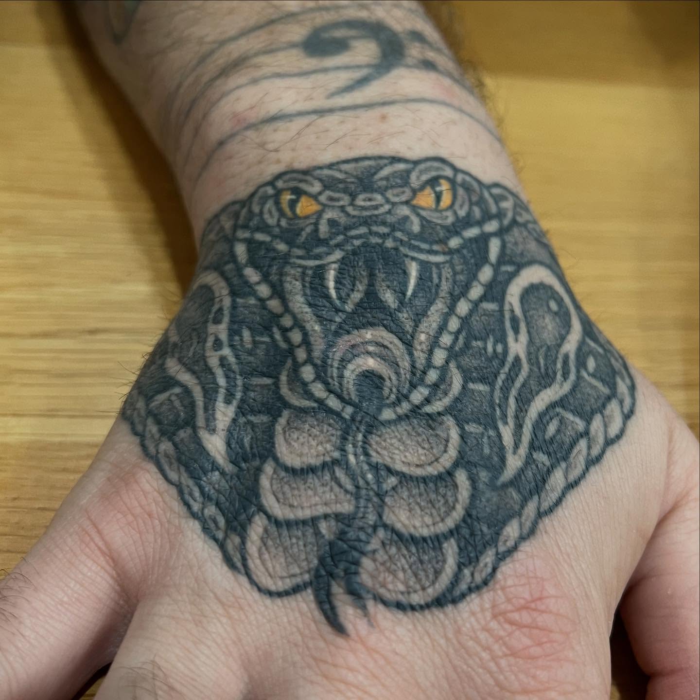 Neo-traditional cobra snake hand tattoo in black and grey by Nicholas Tattoo, Camden NSW