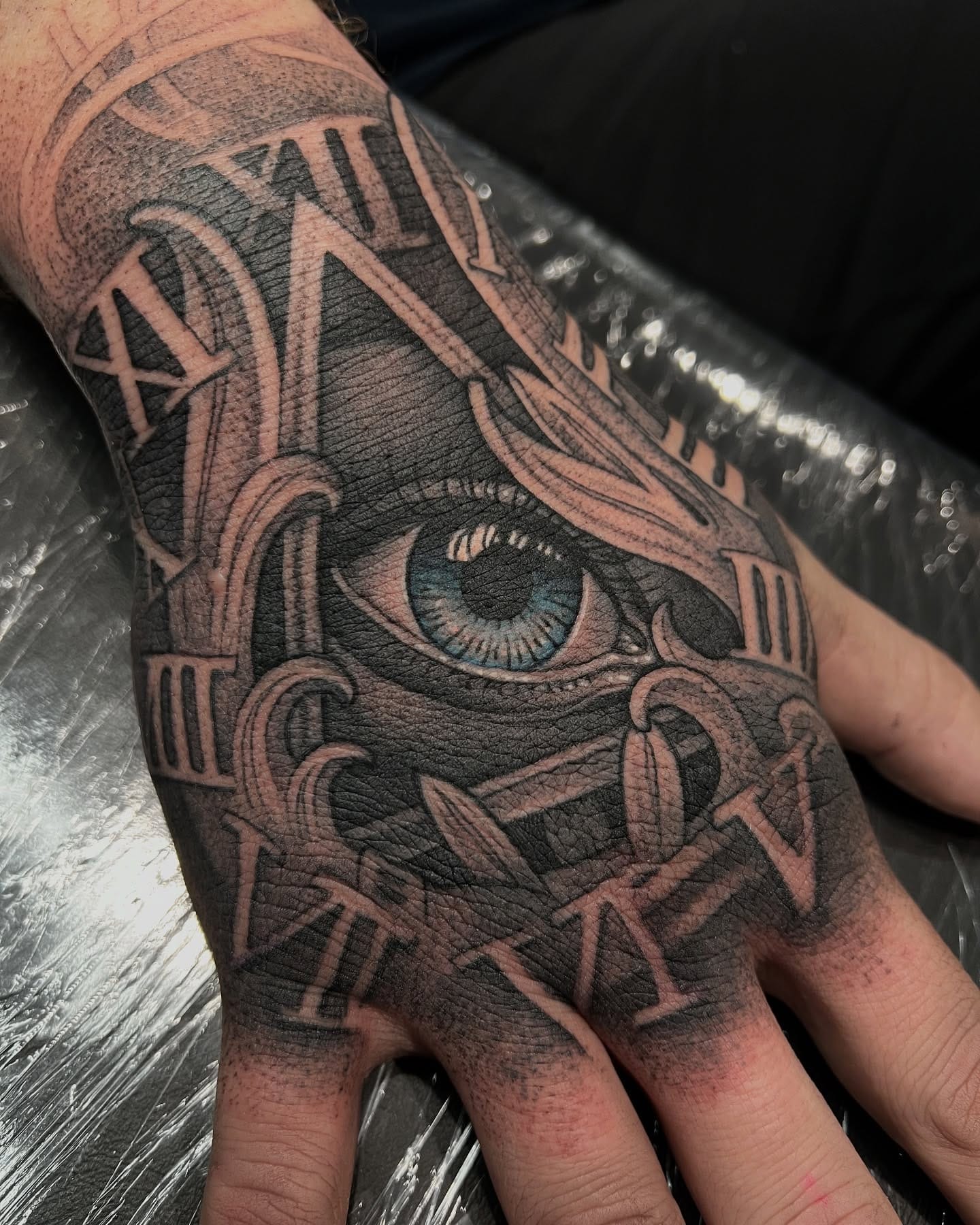 Black and grey realism eye with roman numeral clock hand tattoo by Nicholas Tattoo, Camden NSW