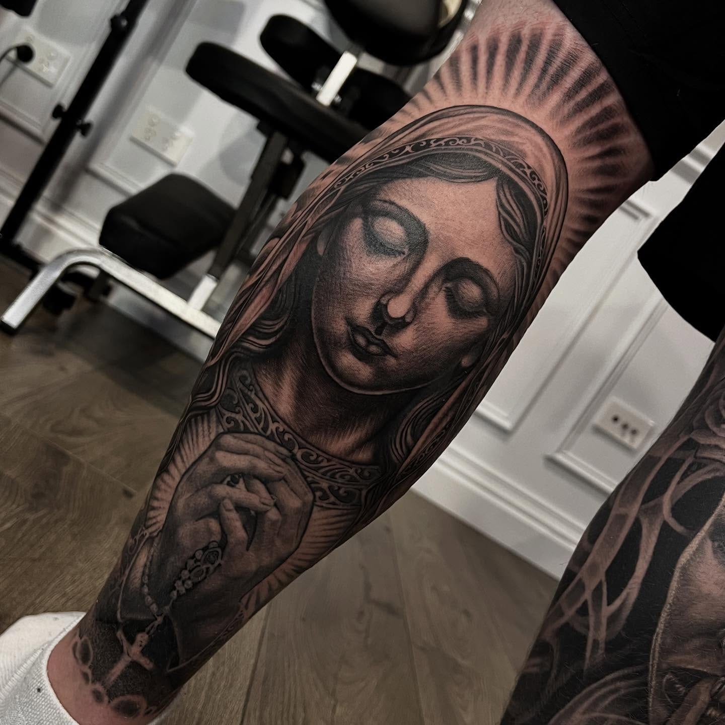 Black and grey realism Virgin Mary with rosary beads tattoo by Nicholas Tattoo, Camden NSW